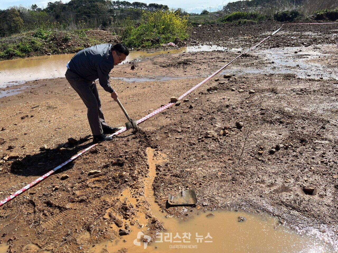 아침까지 내린 비로 물바다가 된 교회터에 기공예배를 드리기 위해 애쓰는 선발대 모습