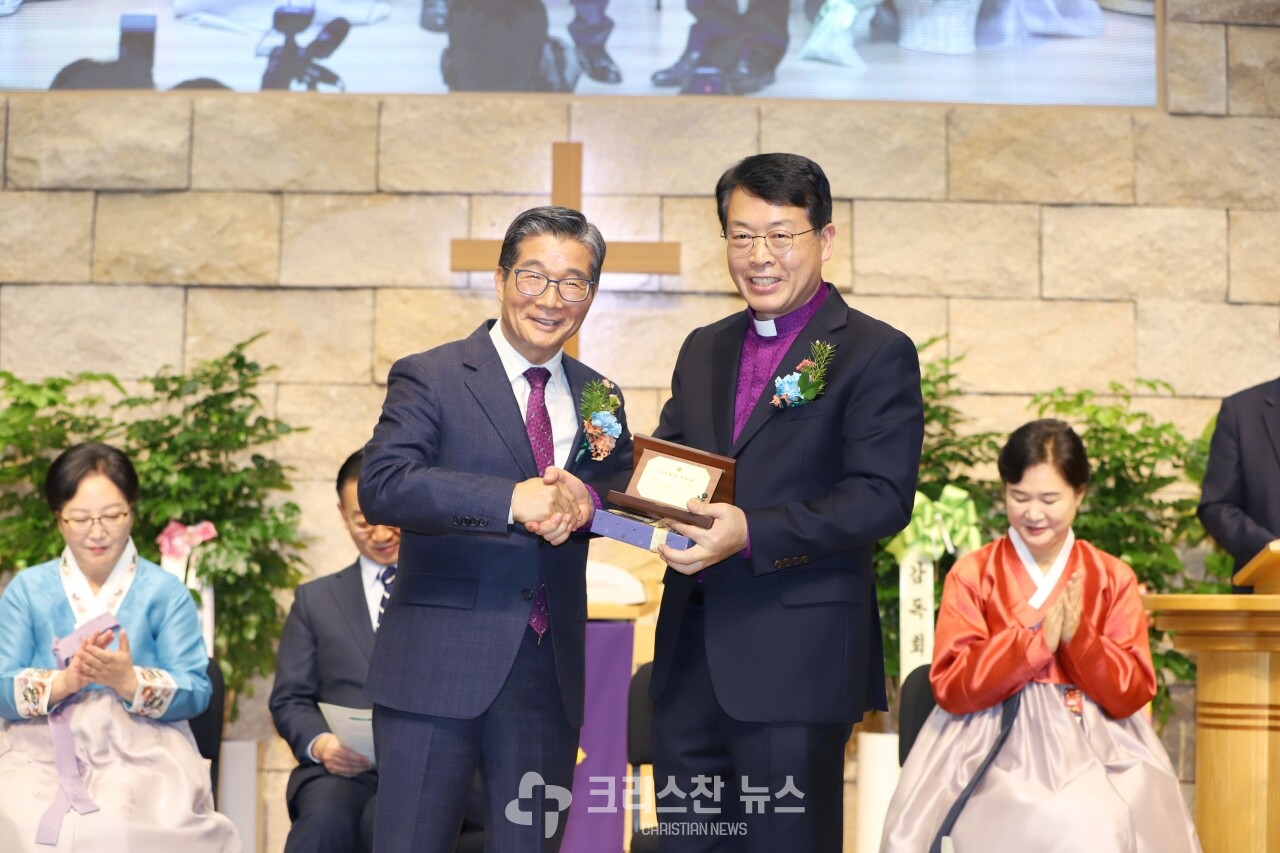 취임 축하패를 전달하는 한성호 목사(감신82동기 회장)