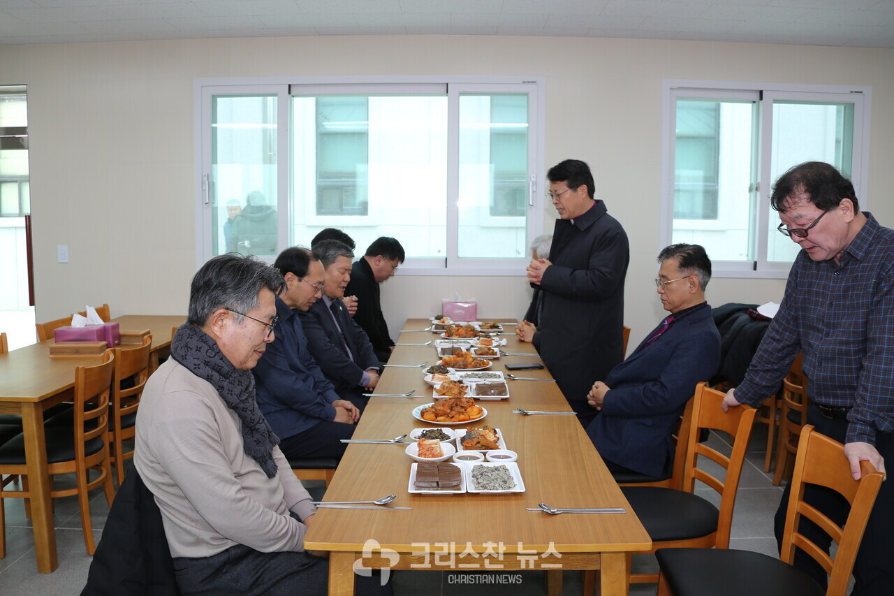 자월교회측에서 정성스럽게 차린 식사를 하기 전에 황규진 감독이 기도하고 있다 