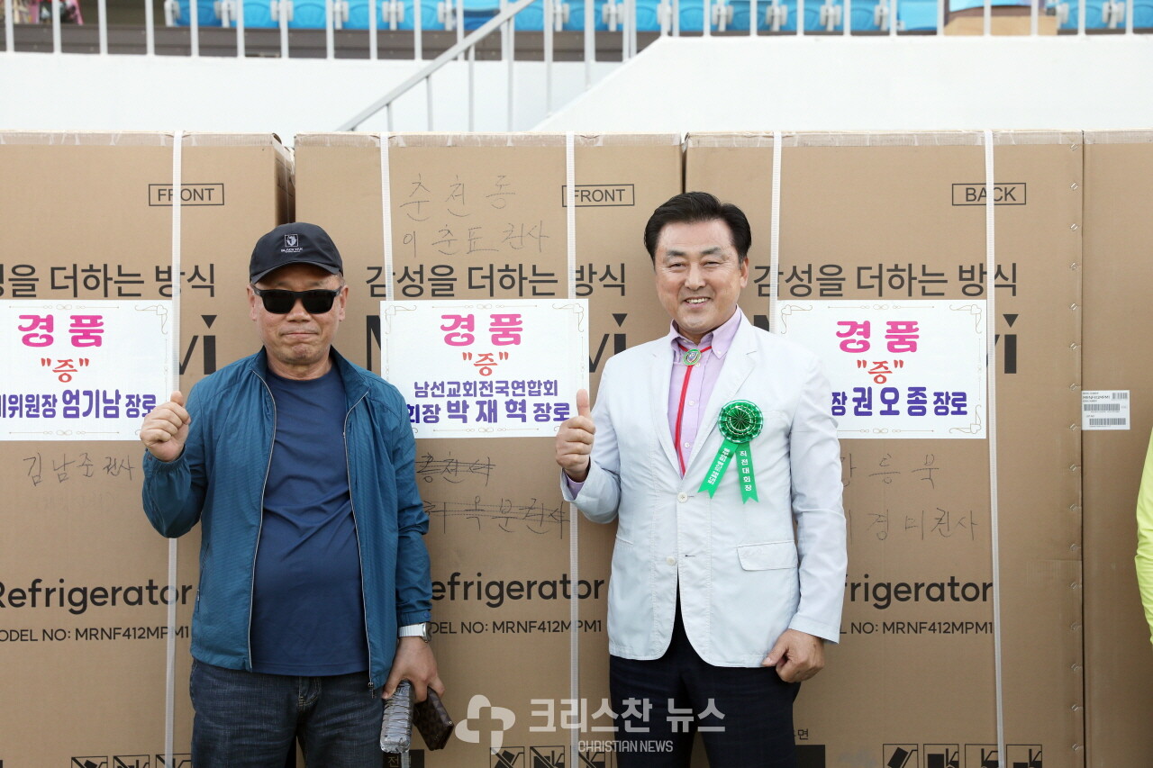 경품 당첨자와 기념 촬영을 하는 박재혁 장로